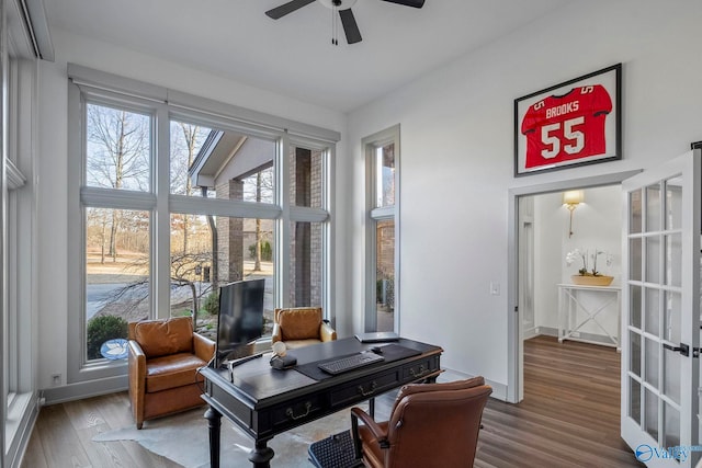 interior space with french doors, baseboards, a ceiling fan, and wood finished floors