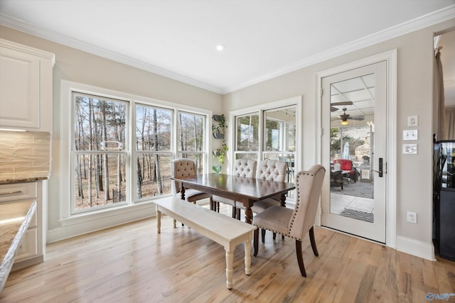 dining space with ornamental molding and light hardwood / wood-style floors