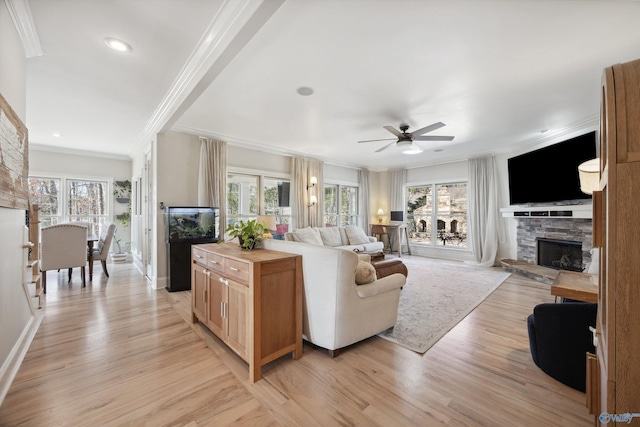 living room with crown molding, a stone fireplace, light hardwood / wood-style floors, and ceiling fan