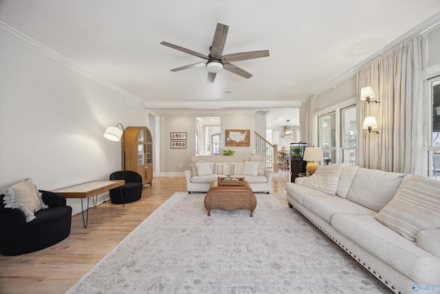 living room with light hardwood / wood-style flooring, ornamental molding, and ceiling fan