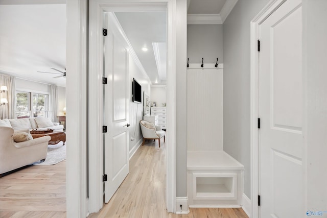 mudroom featuring ornamental molding, a barn door, ceiling fan, and light hardwood / wood-style flooring