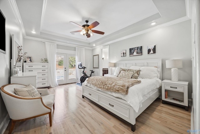 bedroom featuring a raised ceiling, access to exterior, light hardwood / wood-style floors, and french doors