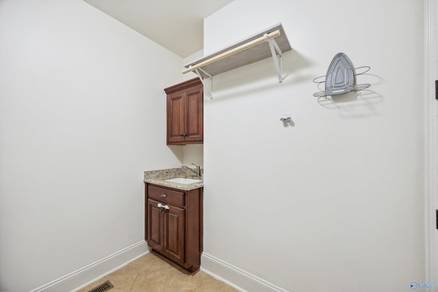 laundry area with sink and light tile patterned floors