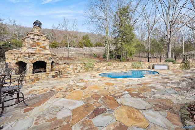 view of pool with a patio area and an outdoor stone fireplace