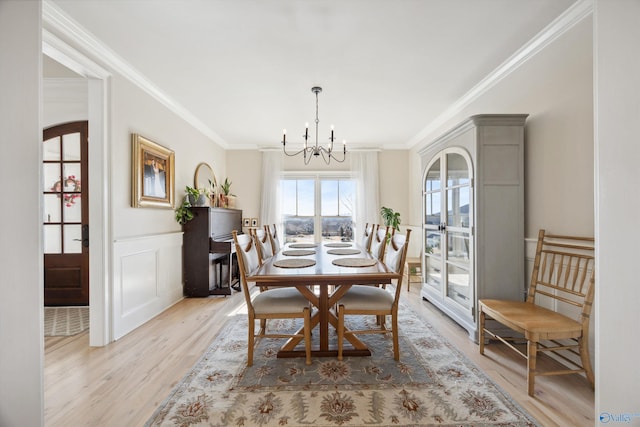 dining room featuring crown molding, a chandelier, and light wood-type flooring