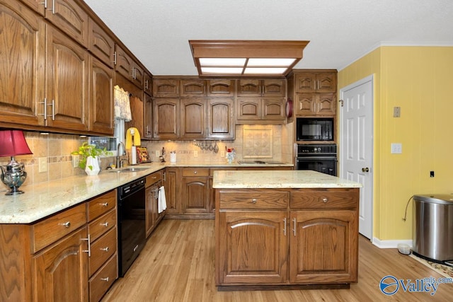 kitchen featuring sink, black appliances, light hardwood / wood-style flooring, a kitchen island, and backsplash