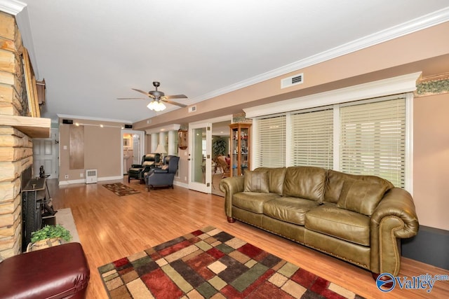 living room with hardwood / wood-style floors, a fireplace, ornamental molding, and ceiling fan