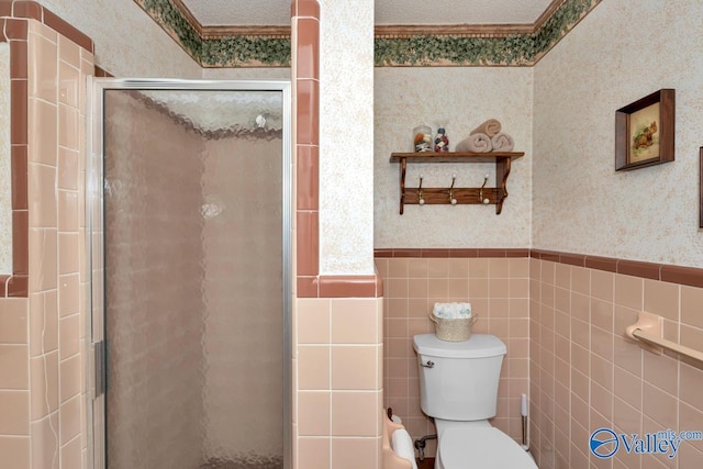 bathroom featuring tile walls, a shower with door, and toilet