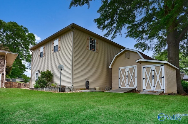 rear view of property featuring an outdoor structure and a yard