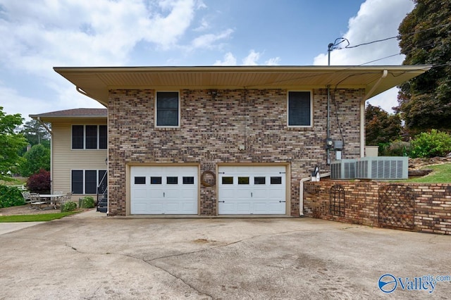 view of front facade featuring a garage and central AC unit