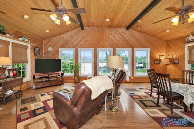 living room with lofted ceiling with beams, wood ceiling, wooden walls, and light hardwood / wood-style flooring