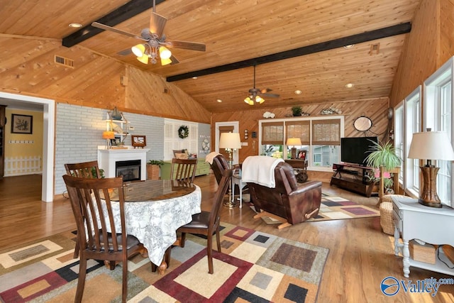 dining area with beamed ceiling, wood walls, and a wealth of natural light