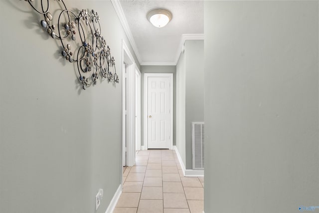 hallway featuring baseboards, visible vents, a textured ceiling, crown molding, and light tile patterned flooring