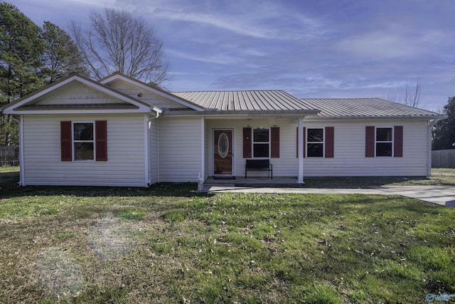 single story home with covered porch, metal roof, and a front yard