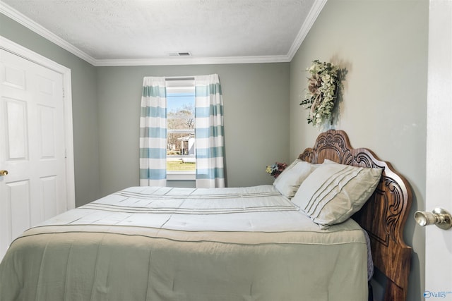 bedroom with visible vents, ornamental molding, and a textured ceiling