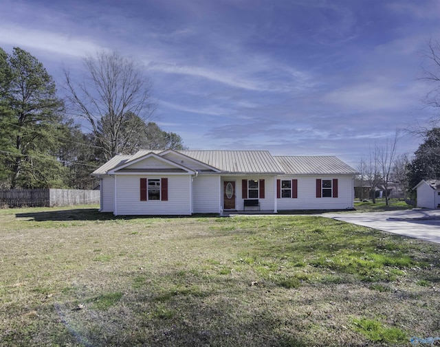 single story home with metal roof, fence, and a front lawn