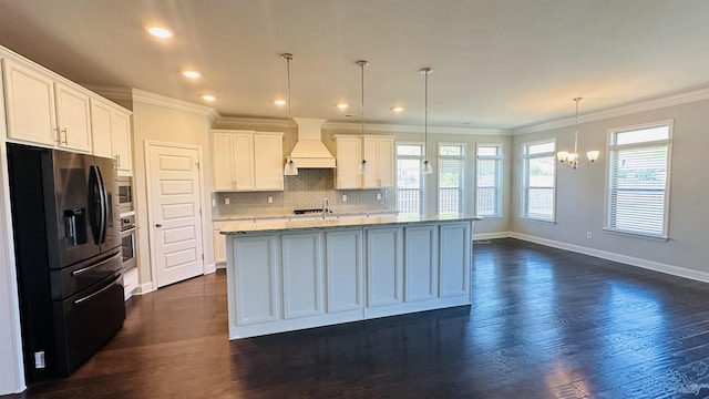 kitchen with refrigerator with ice dispenser, premium range hood, crown molding, a chandelier, and decorative backsplash