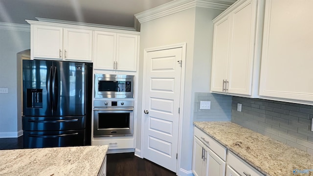 kitchen featuring appliances with stainless steel finishes, crown molding, backsplash, white cabinetry, and light stone counters