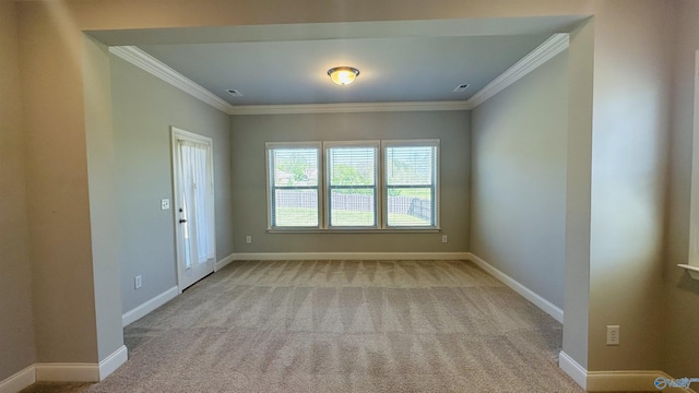 unfurnished room with crown molding, light carpet, and baseboards