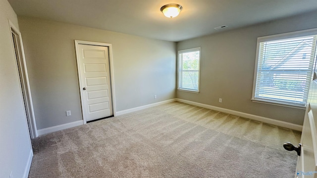 unfurnished room with carpet flooring and baseboards