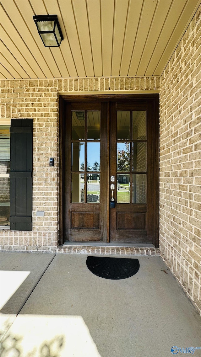 entrance to property featuring brick siding