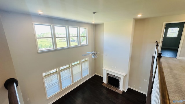 unfurnished living room with a ceiling fan, plenty of natural light, baseboards, recessed lighting, and a fireplace