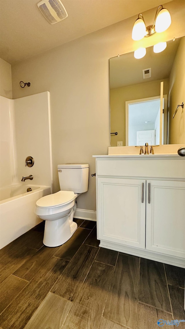 full bathroom featuring toilet, vanity, wood finished floors, bathing tub / shower combination, and baseboards