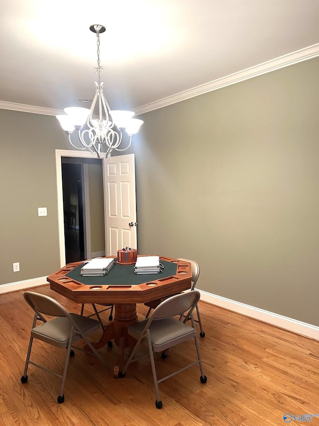 dining room with an inviting chandelier, ornamental molding, and light hardwood / wood-style floors