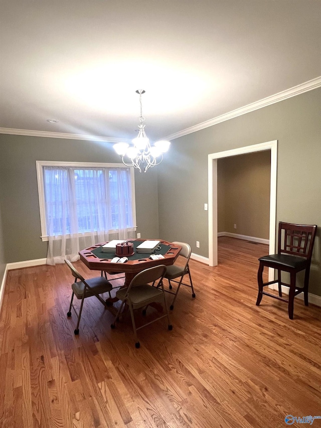 dining area featuring a notable chandelier, light hardwood / wood-style flooring, and ornamental molding