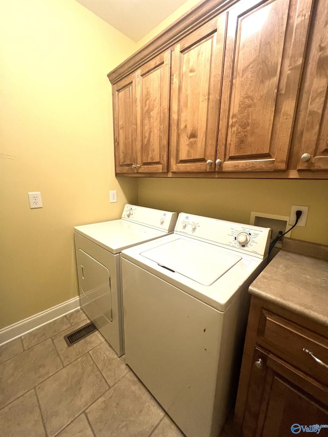 laundry area featuring cabinets and washing machine and clothes dryer