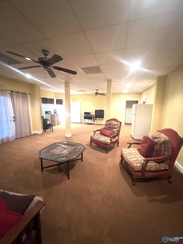 carpeted living room featuring a drop ceiling and ceiling fan