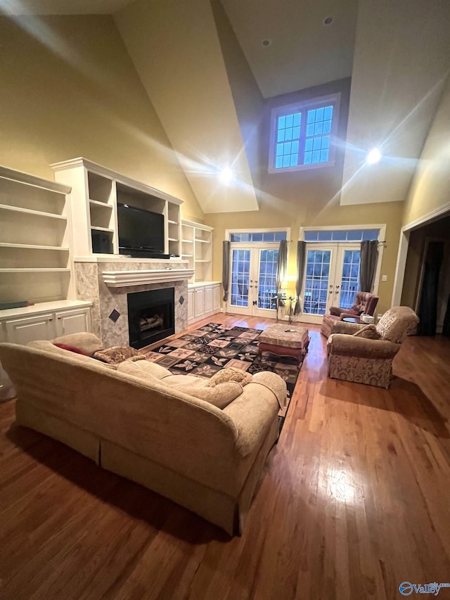 living room with french doors, high vaulted ceiling, and hardwood / wood-style flooring