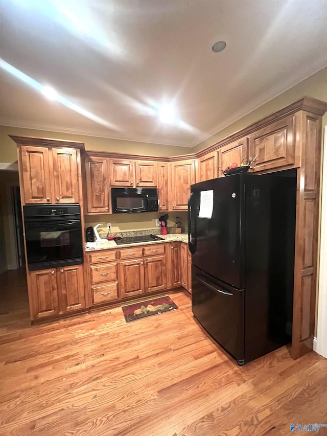 kitchen with light hardwood / wood-style floors and black appliances