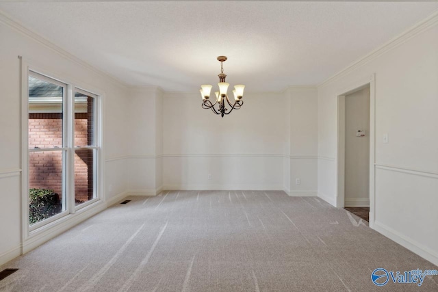 spare room featuring carpet floors, a chandelier, and ornamental molding