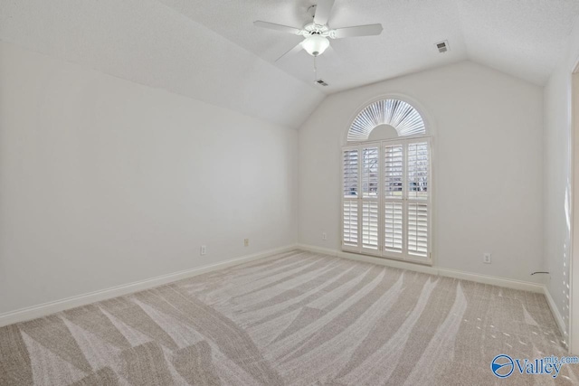 carpeted empty room with vaulted ceiling and ceiling fan