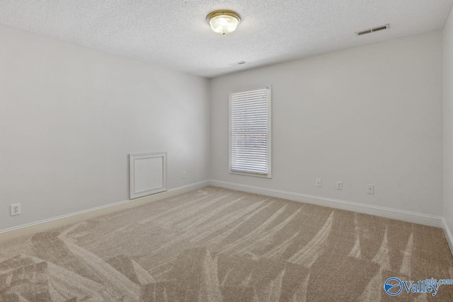 carpeted spare room featuring a textured ceiling