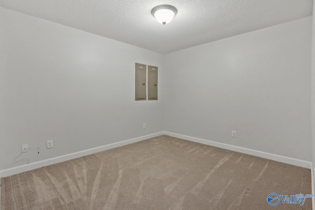 carpeted spare room featuring a textured ceiling