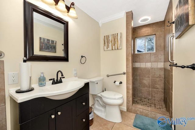 bathroom with vanity, ornamental molding, tiled shower, toilet, and tile patterned floors