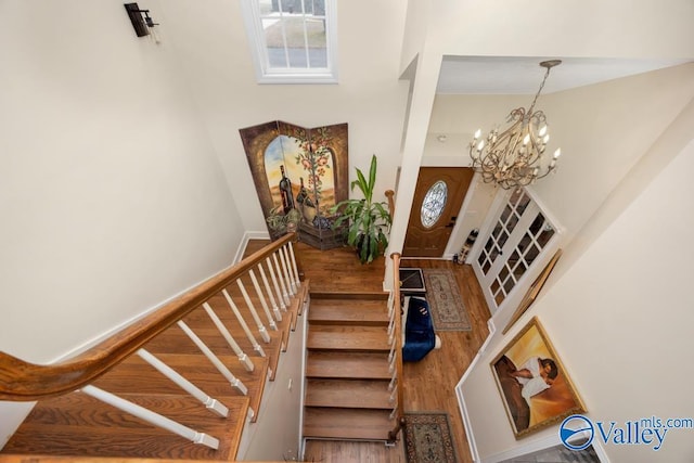 staircase featuring an inviting chandelier and hardwood / wood-style floors