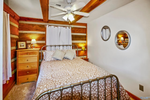 bedroom with beam ceiling, ceiling fan, and wood walls