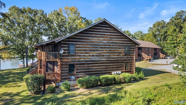 view of property exterior with a lawn and a water view