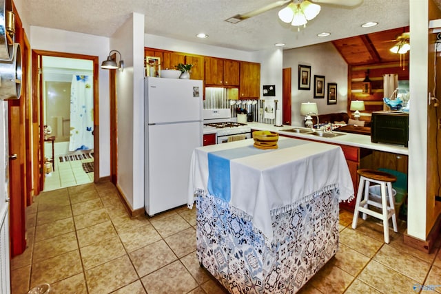 kitchen featuring ceiling fan, a textured ceiling, sink, and white appliances