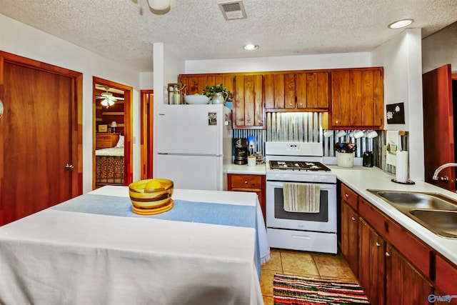 kitchen with ceiling fan, light tile patterned floors, sink, white appliances, and a textured ceiling