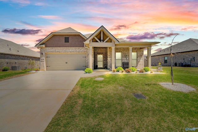 view of front of home with central AC unit, a garage, brick siding, a front lawn, and driveway