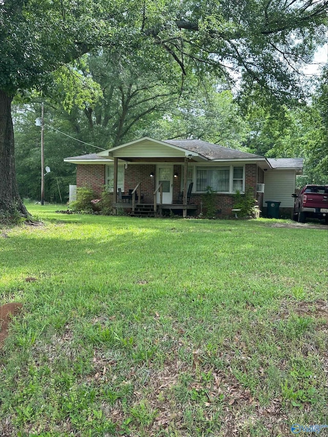 view of front of house featuring covered porch, a front lawn, and brick siding