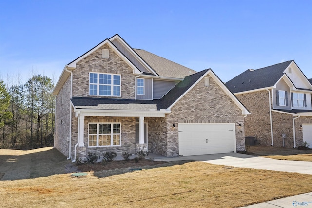 craftsman inspired home featuring concrete driveway, a front lawn, an attached garage, and brick siding