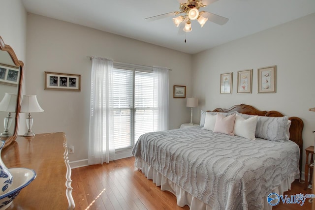 bedroom featuring baseboards, light wood-type flooring, and ceiling fan