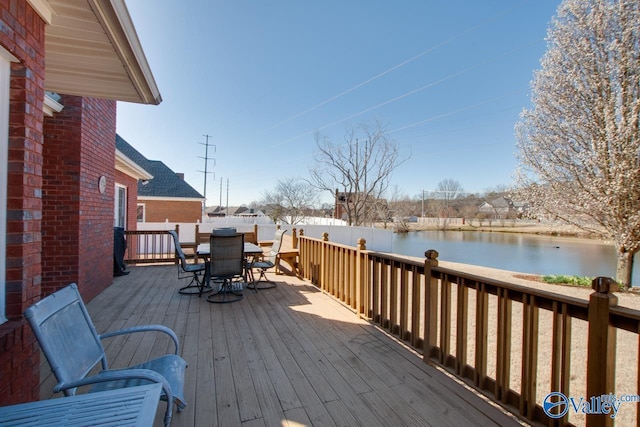 wooden deck with outdoor dining area and a water view