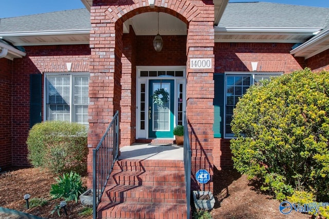 property entrance with brick siding and roof with shingles