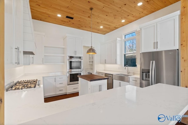 kitchen featuring white cabinetry, wooden ceiling, butcher block countertops, decorative light fixtures, and appliances with stainless steel finishes